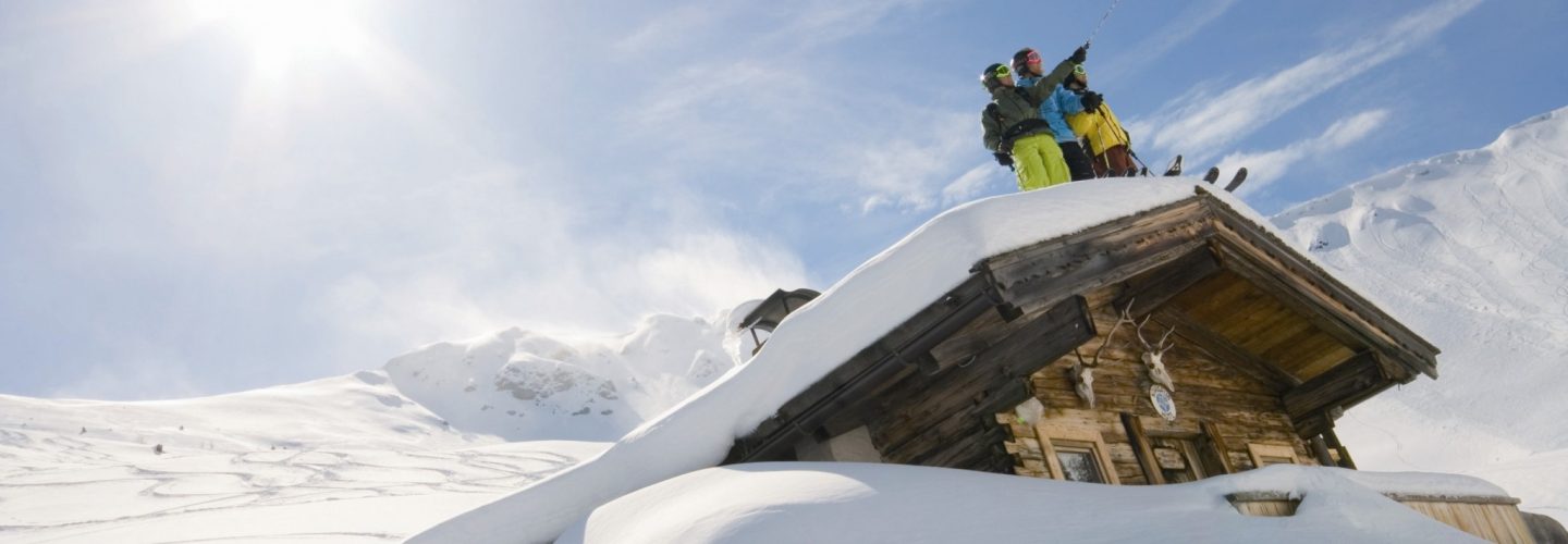 Deep snow skiers on a hut roof Alpbach Credit Alpbachtal 