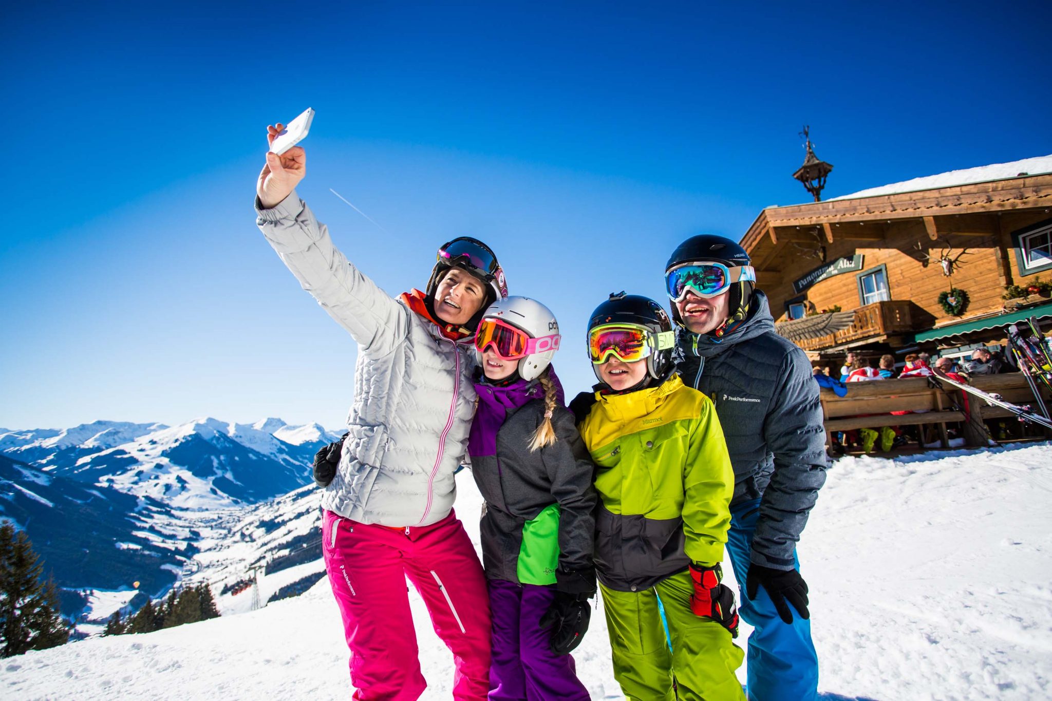 Выбор горнолыжного курорта. Люди на горнолыжном курорте. Зимний курорт. Семья в горах. Туристы зимой.