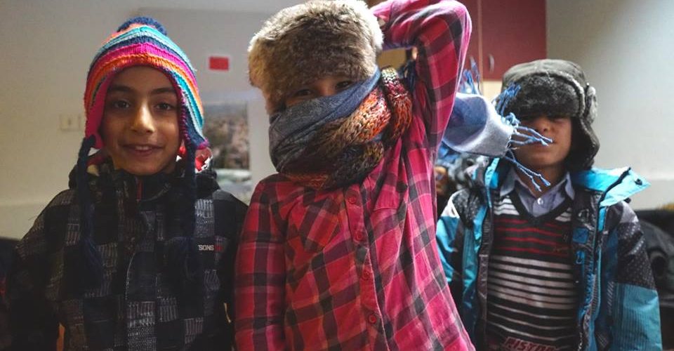 Riders for Refugees refugee children in their warm clothing by Alexis de Tarade